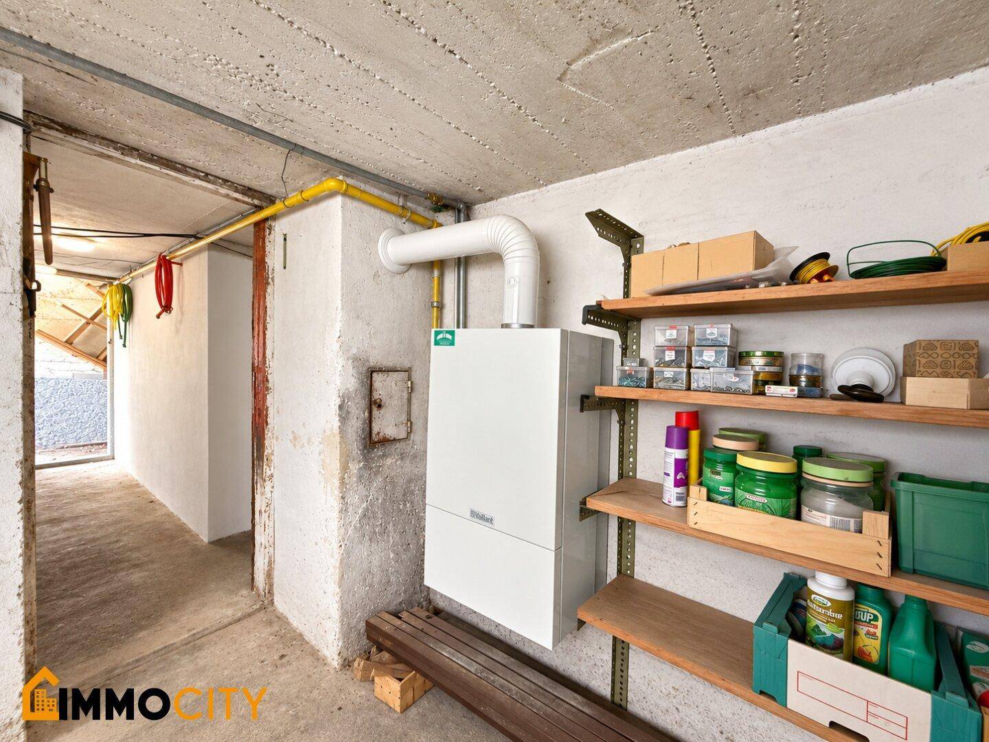 Heizungsraum im Keller mit Gastherme und Lagerregalen für diverse Gegenstände.