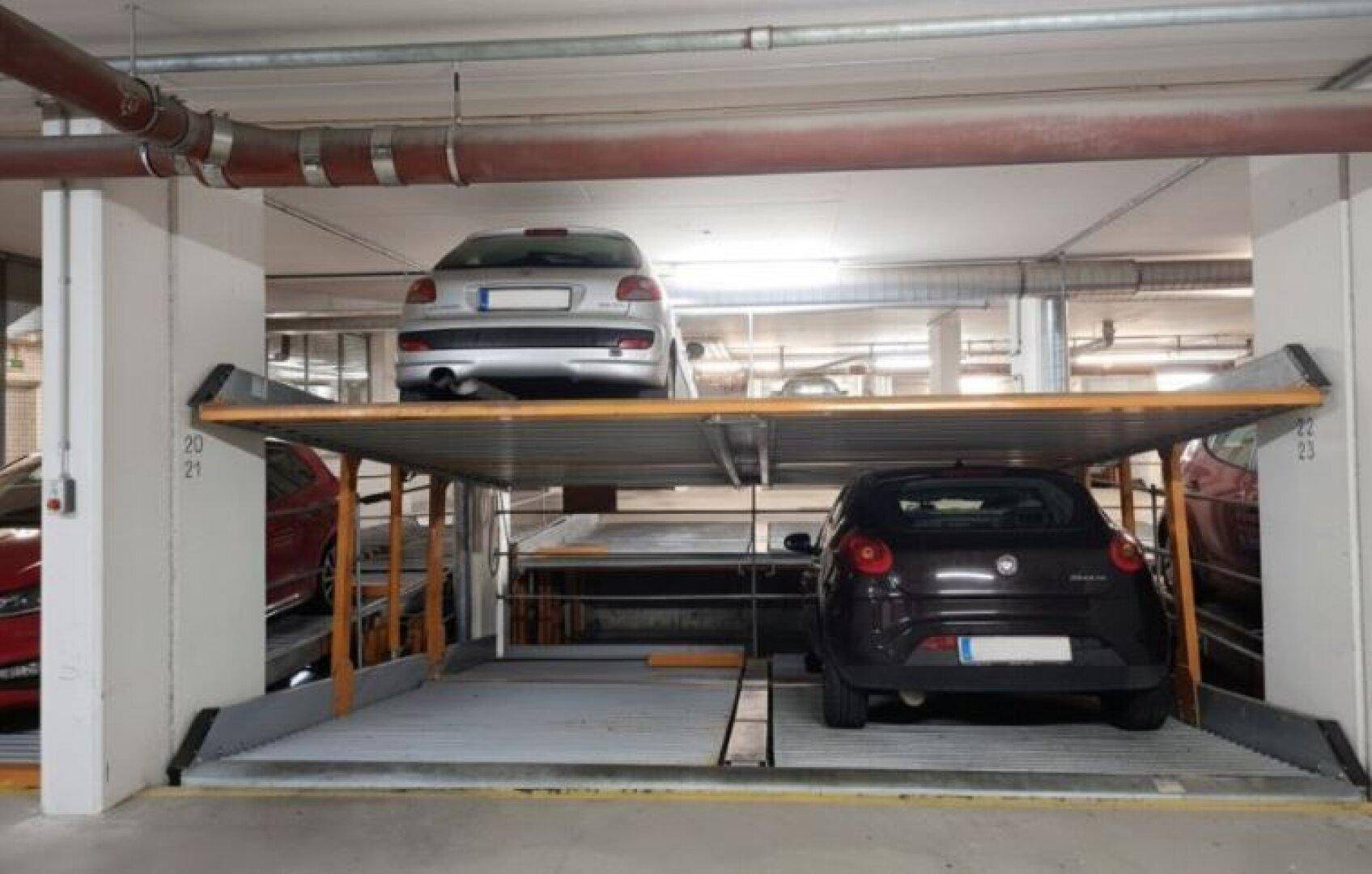 Tiefgarage mit modernem Doppelparker-System für zwei Fahrzeuge übereinander in sauberem Zustand.
