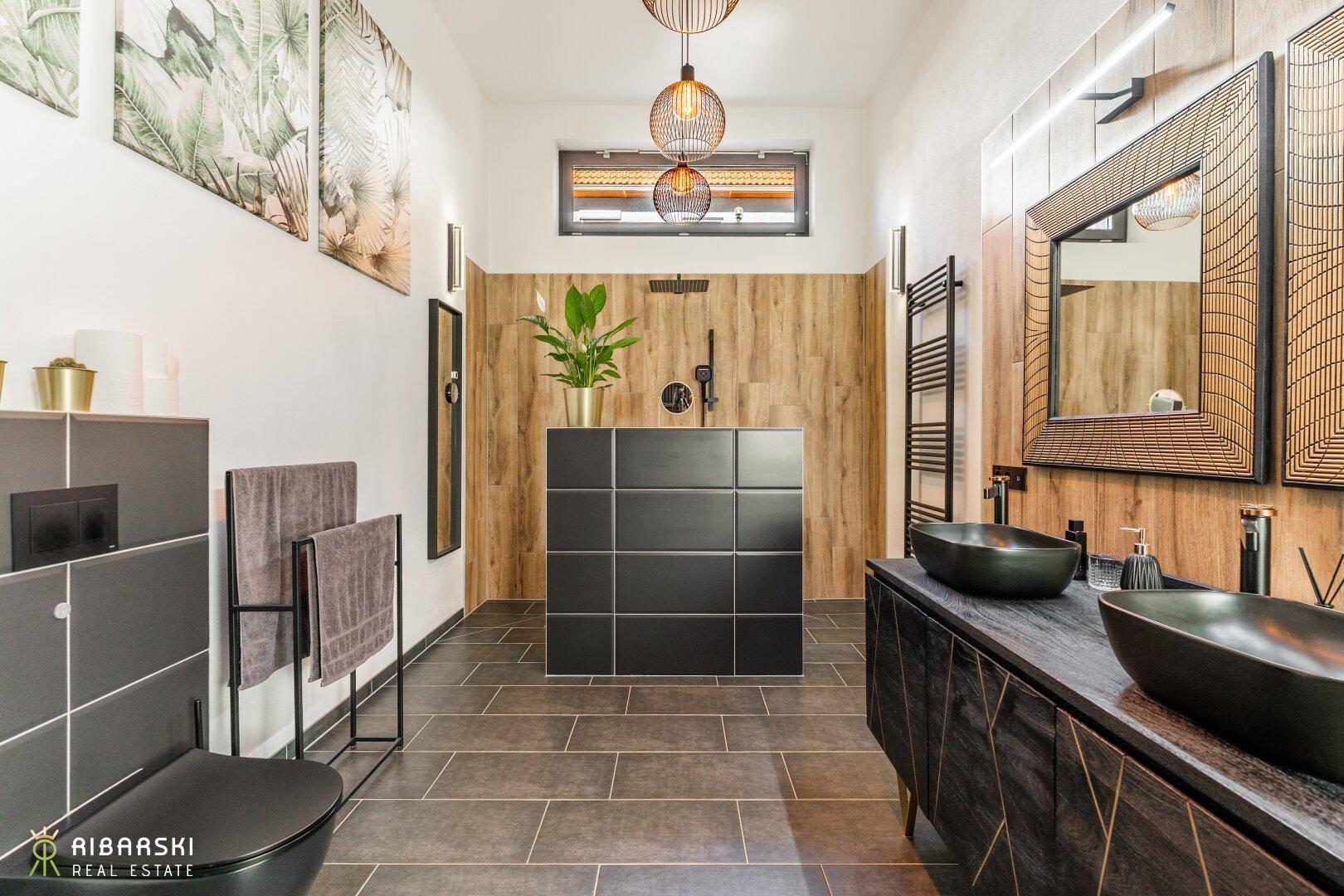 Modernes Badezimmer mit dunklen Fliesen, Holzdetails, Doppelwaschbecken und begehbarer Dusche.