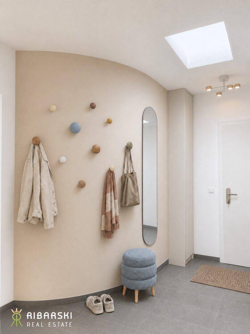 Moderner Eingangsbereich mit Garderobe, Spiegel und hellem Oberlicht.