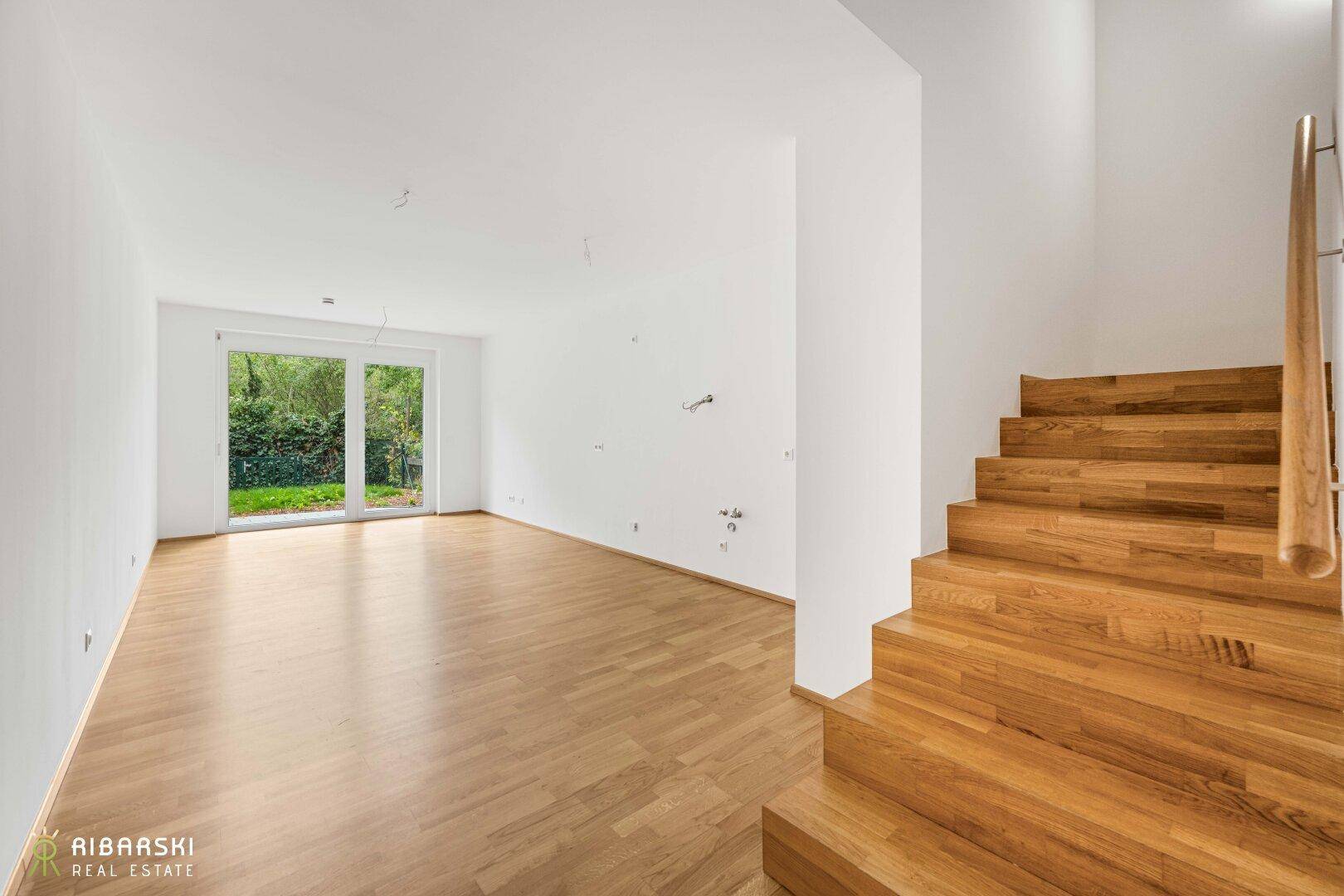 Heller Wohnbereich mit Eichenparkett und Zugang zum Garten, ideal für offenes Wohnen.