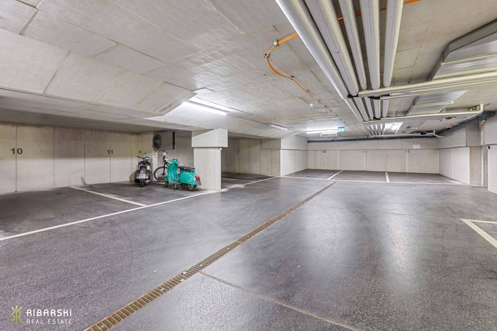 Geräumige Tiefgarage mit markierten Stellplätzen und guter Beleuchtung.