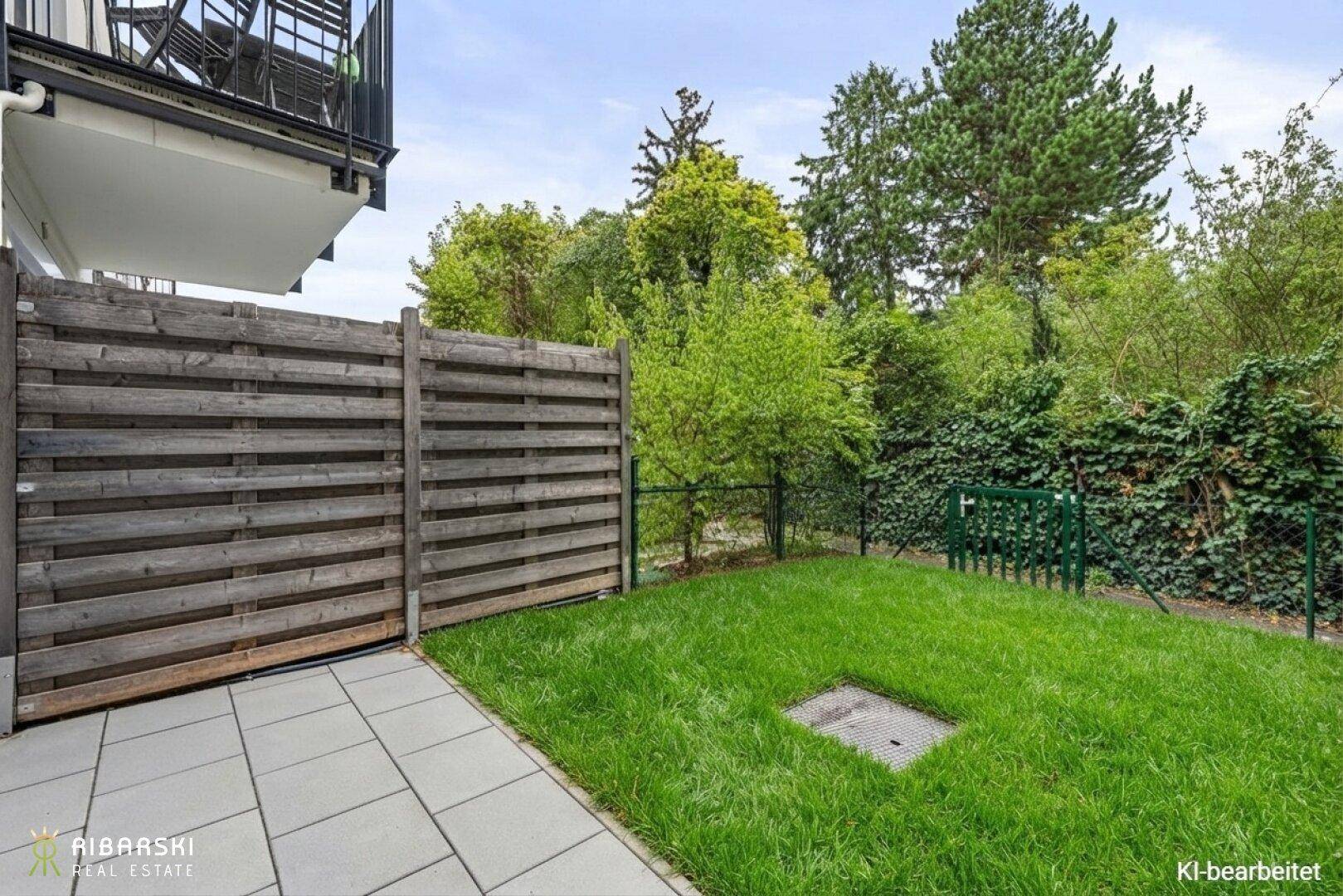 Kleiner privater Gartenbereich mit gepflasterter Terrasse und Holzzaun.