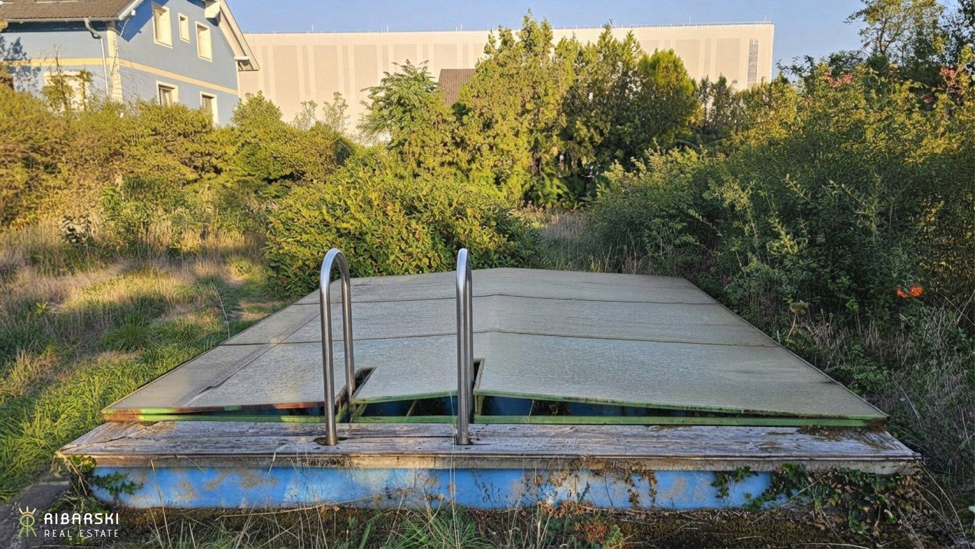 Alter, abgedeckter Swimmingpool in einem verwilderten Gartenbereich mit umliegender Vegetation.