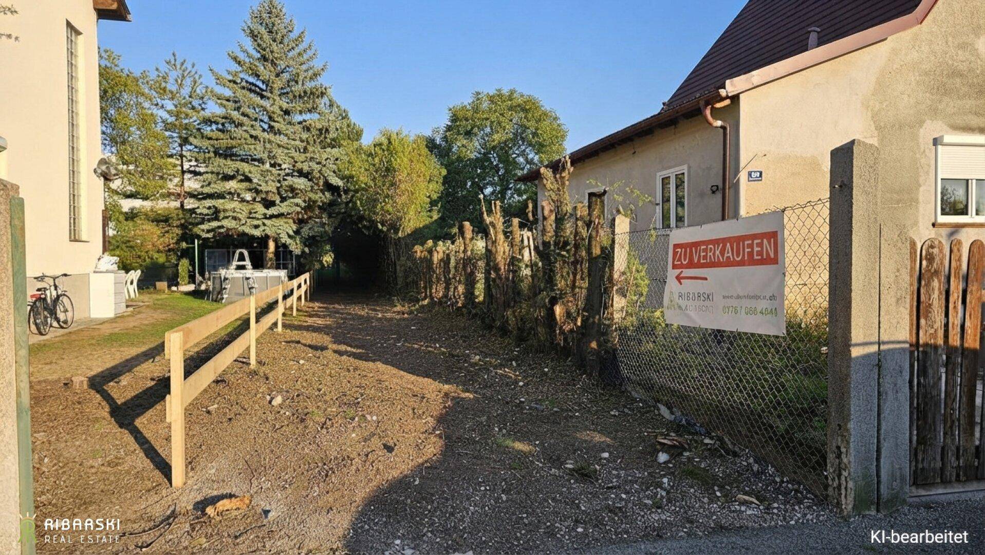 Gartenweg mit Holzzaun und einem "Zu verkaufen"-Schild, führt zu einem Haus.