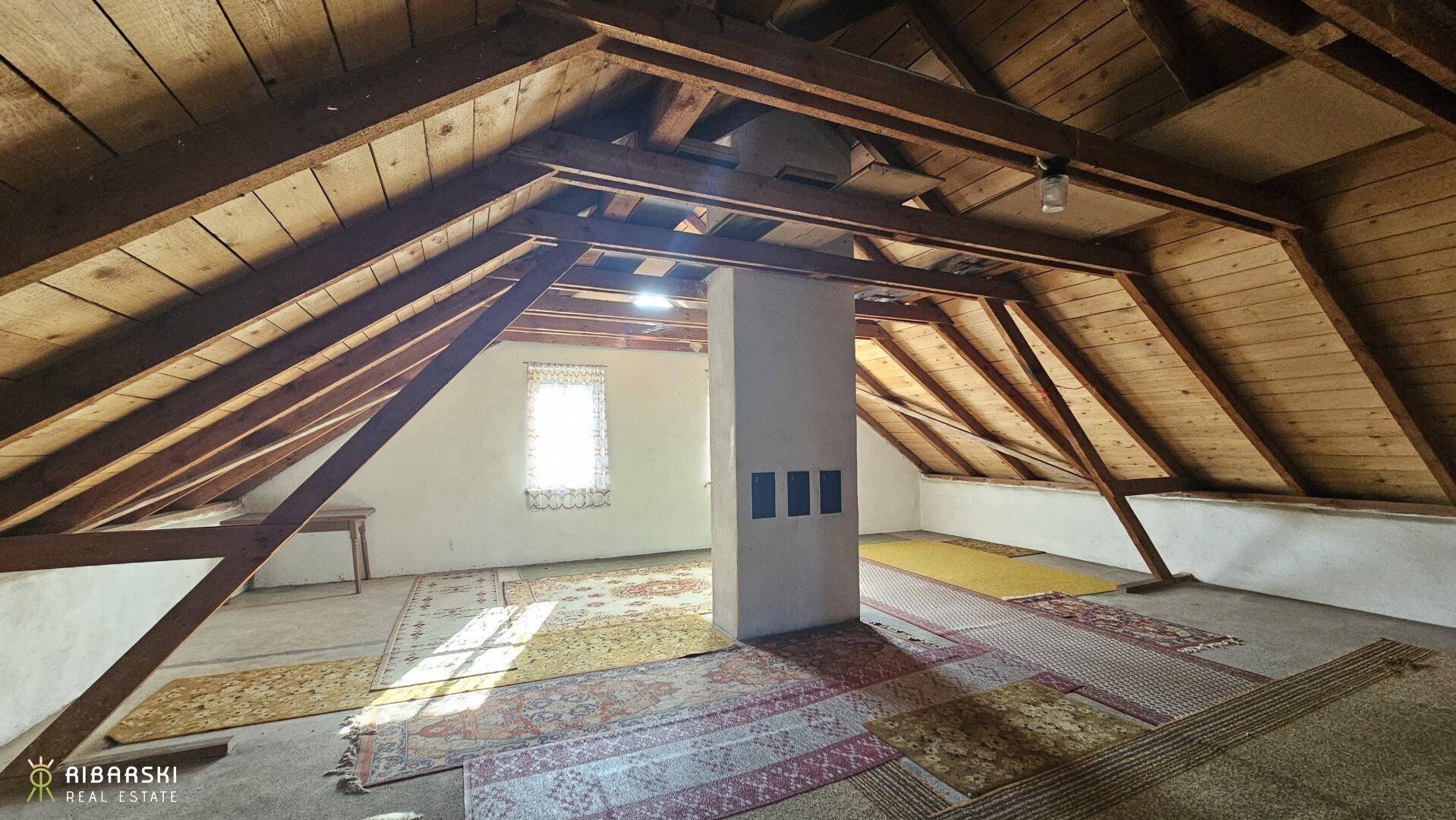 Geräumiger, unfertiger Dachboden mit sichtbaren Holzbalken und viel Potenzial für Ausbau.