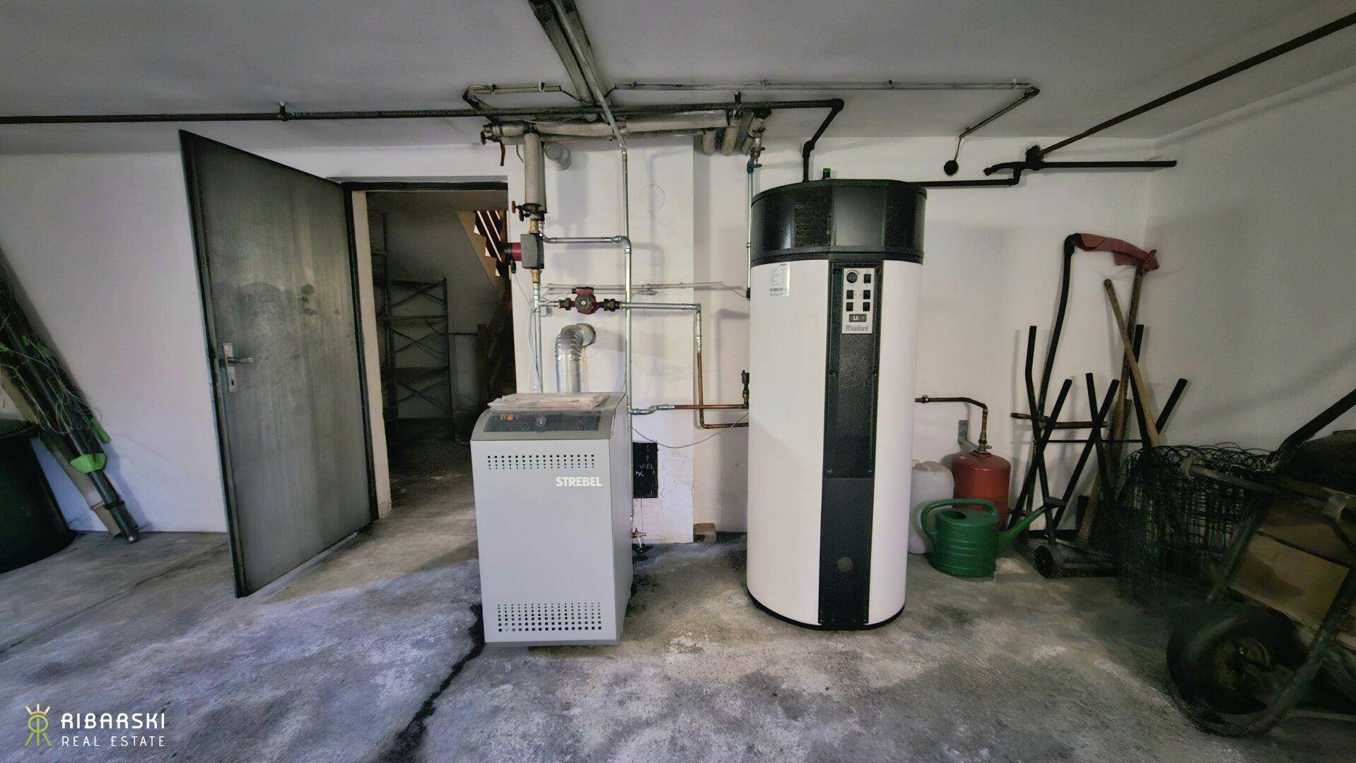 Heizungsraum im Keller mit moderner Wärmepumpe und weiteren Installationen.