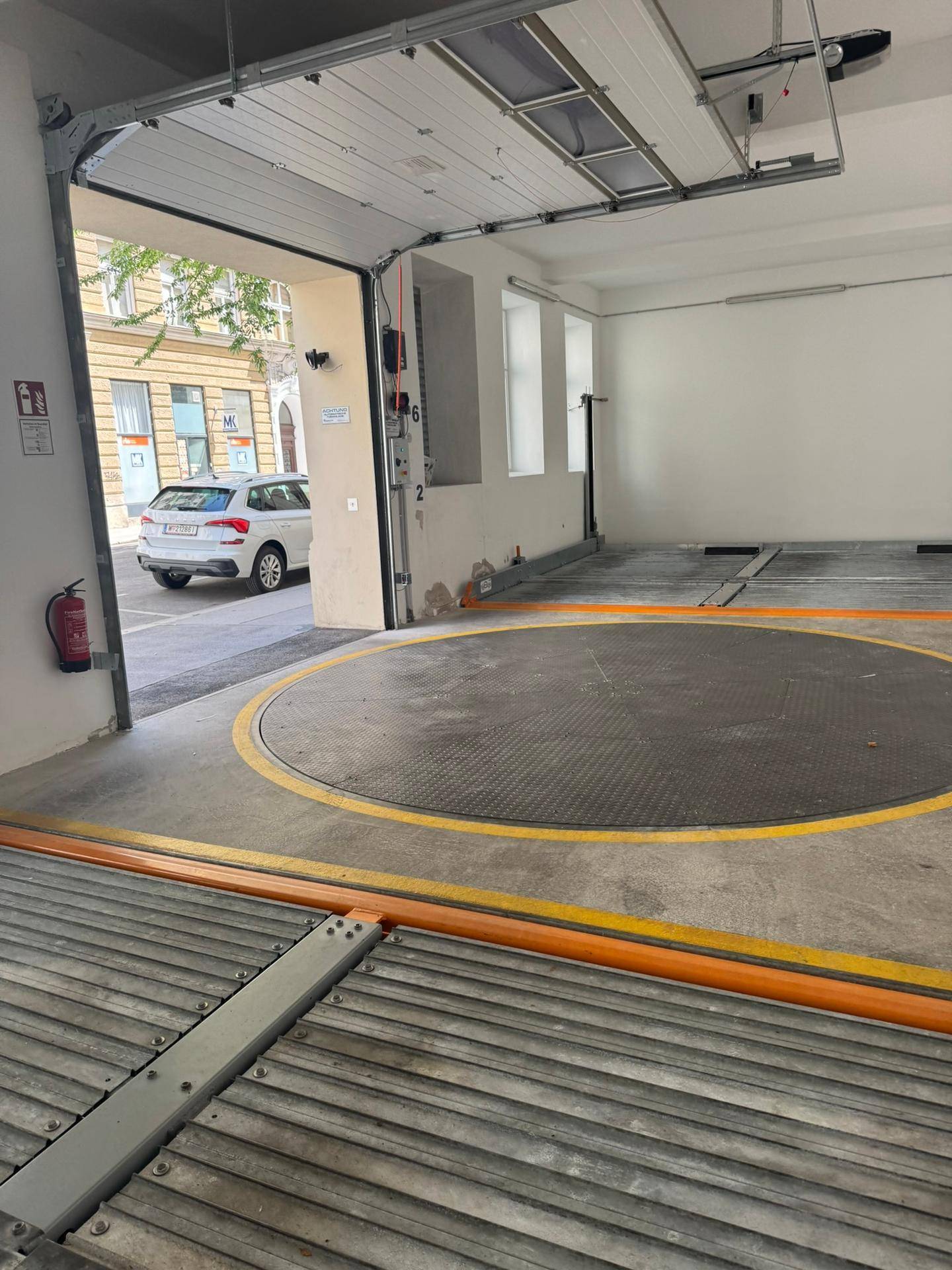 Tiefgarage mit automatischem Garagentor und einer Drehscheibe für Fahrzeuge.