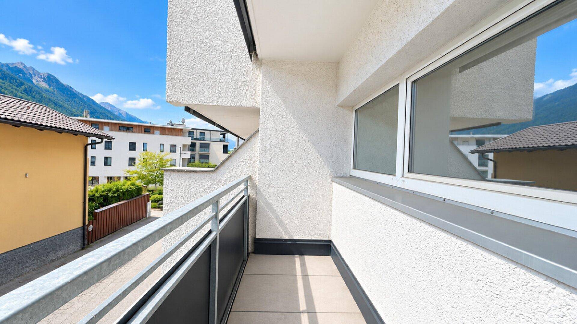 Kleiner Balkon mit Bergblick und Blick auf die umliegende Wohnbebauung.