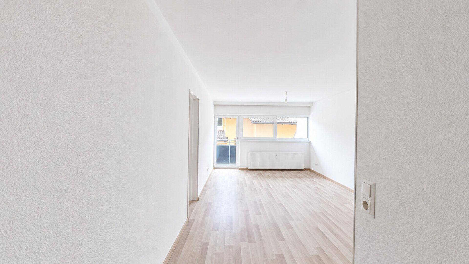Geräumiges, helles Zimmer mit Laminatboden und Balkonzugang, bereit zur individuellen Gestaltung.