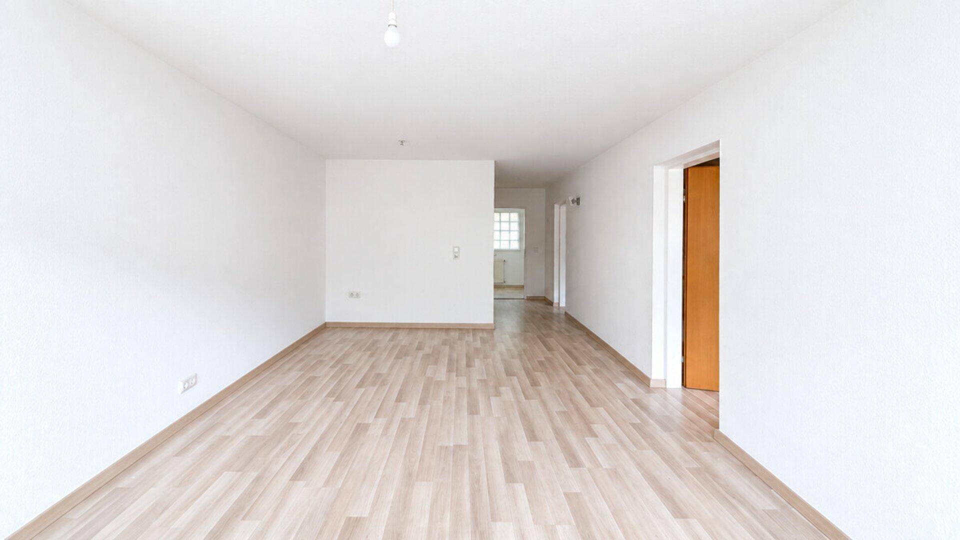 Langer, heller Flur mit Laminatboden, der zu weiteren Räumen führt.