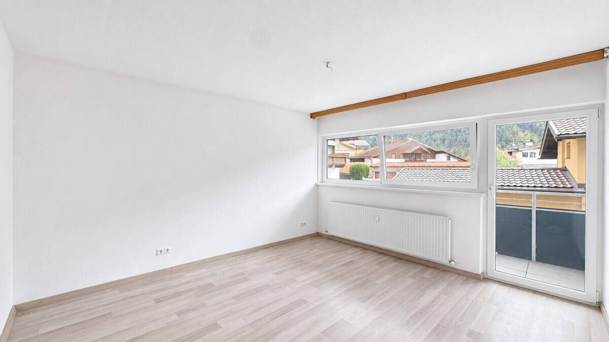 Helles Zimmer mit Laminatboden und Zugang zu einem Balkon, bietet Bergblick.
