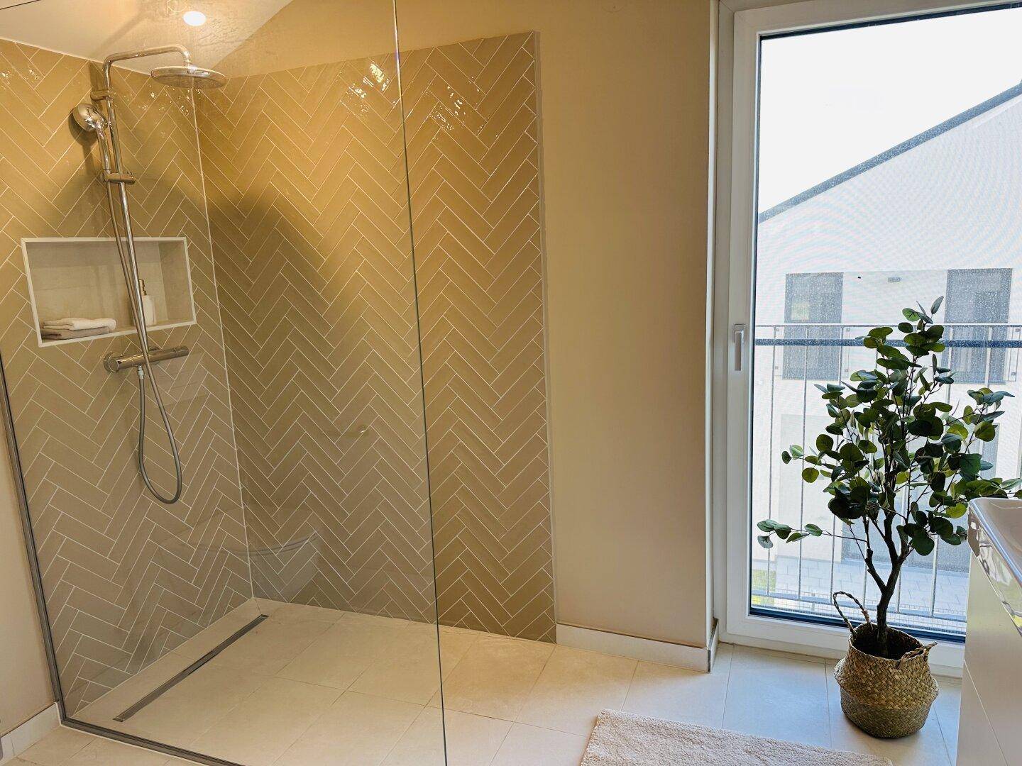 Modernes Badezimmer mit ebenerdiger Dusche, Fliesenwänden und großem Fenster.