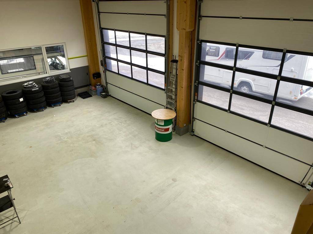 Werkstatt mit Sektionaltoren und Reifenlager, bietet viel Platz für Fahrzeuge und Ausrüstung.