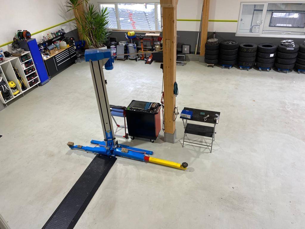 Werkstatt mit Sektionaltoren und Reifenlager, bietet viel Platz für Fahrzeuge und Ausrüstung.