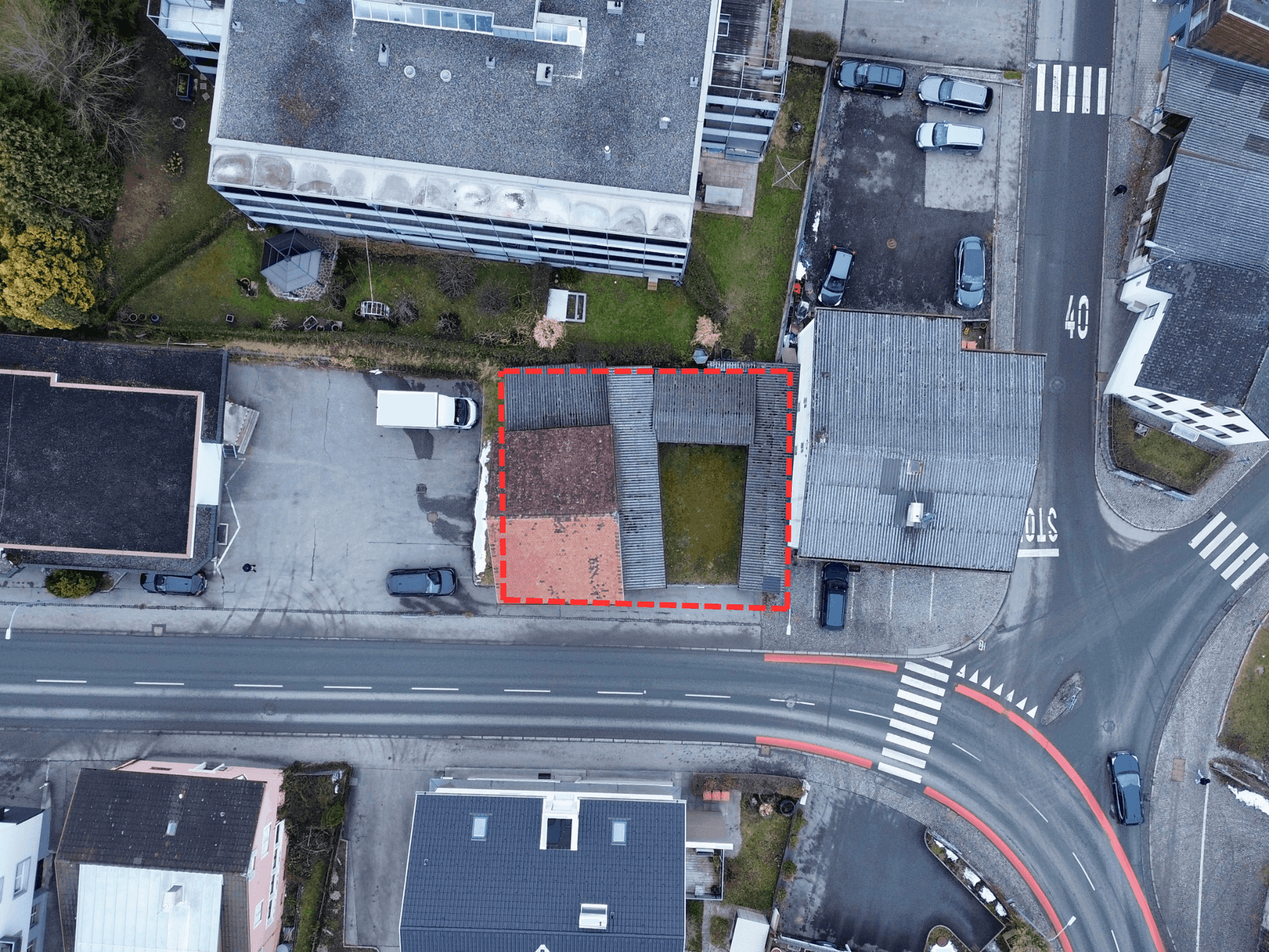 Luftaufnahme des Grundstücks mit roter Umrandung, zeigt das Gebäude, den Hof und die umliegenden Straßen.