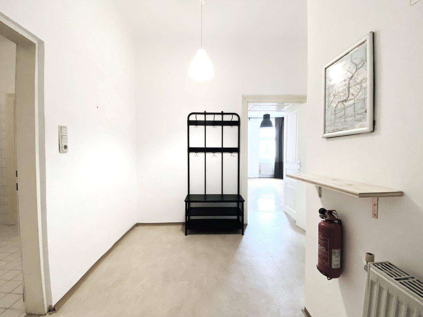 Langer, heller Flur mit Garderobe und Blick in ein weiteres Zimmer.