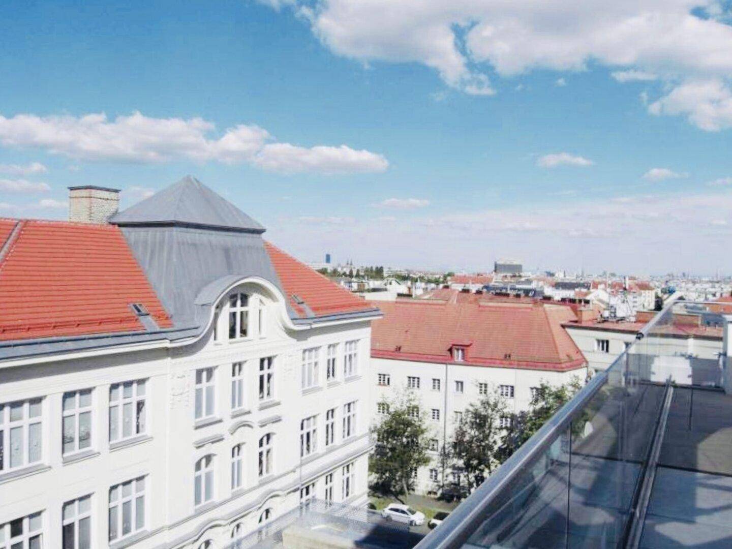 Weitblick über die Dächer der Stadt mit traditionellen roten Ziegeldächern.