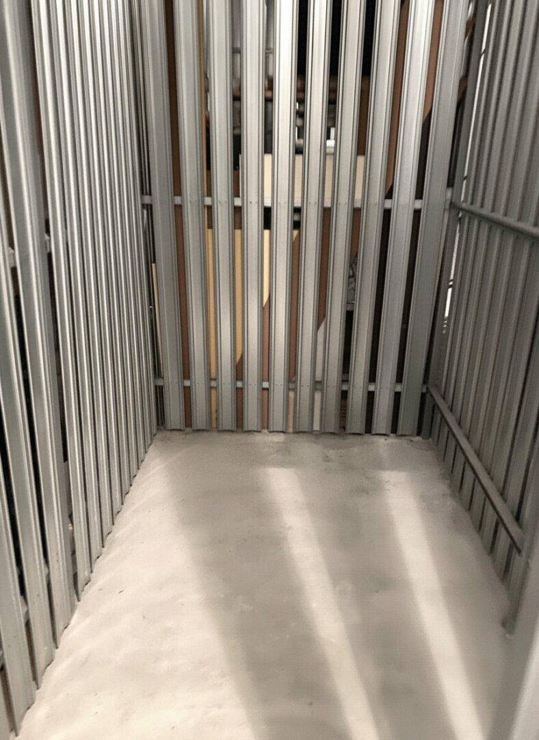 Praktischer Abstellraum mit Metallwänden und Betonboden, ideal für zusätzlichen Stauraum.