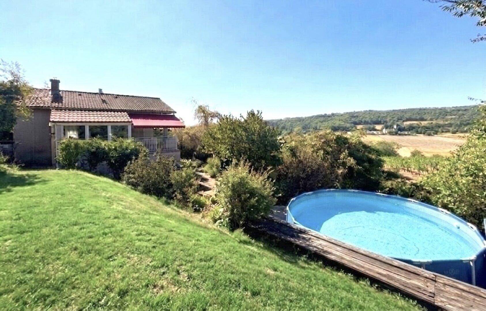 Blick auf das Haus vom Garten aus mit oberirdischem Pool und weitem Blick auf die ländliche Umgebung.