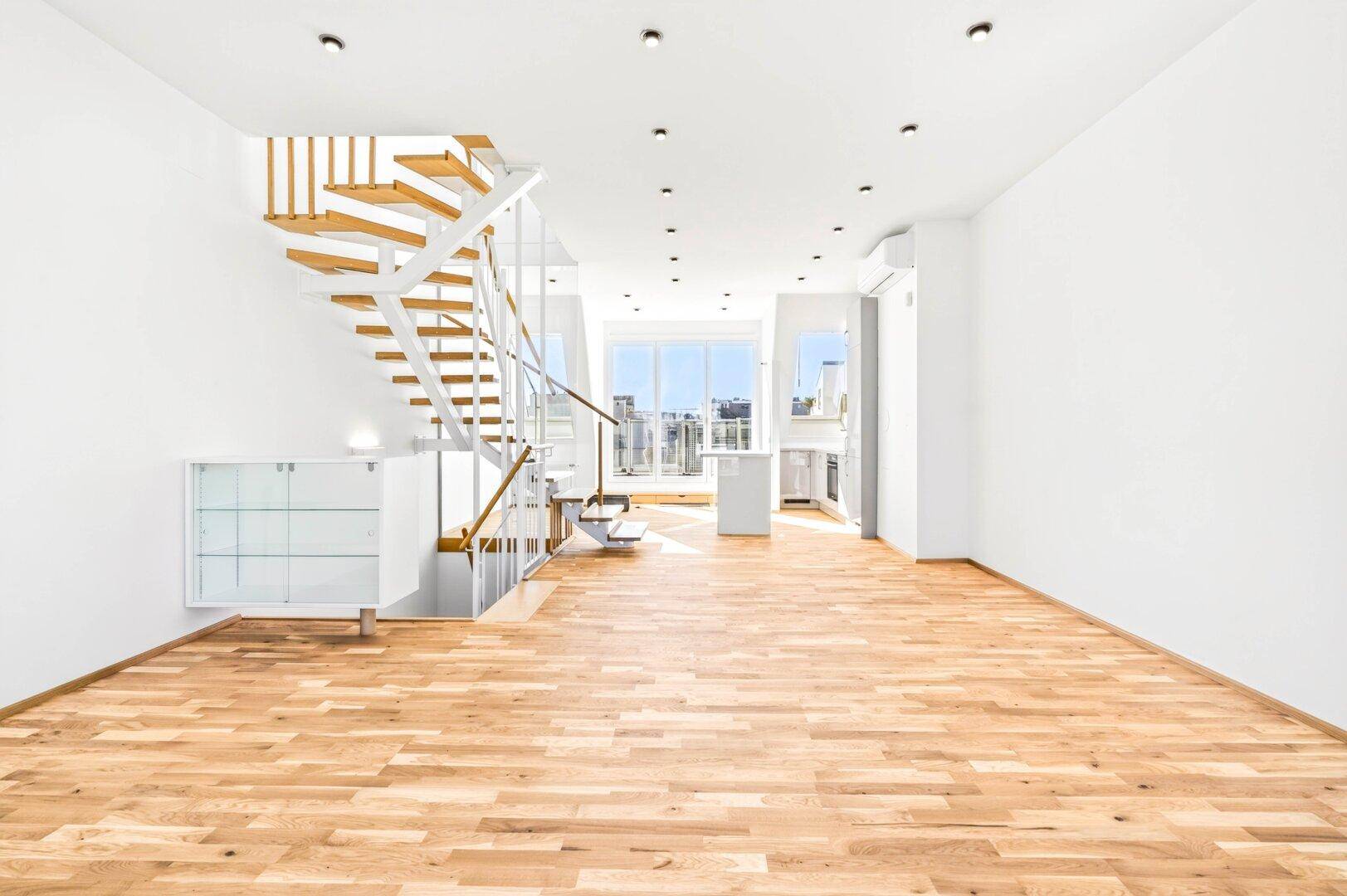 Offener Wohnbereich mit eleganter Holztreppe, Holzboden und Blick auf die Stadt.