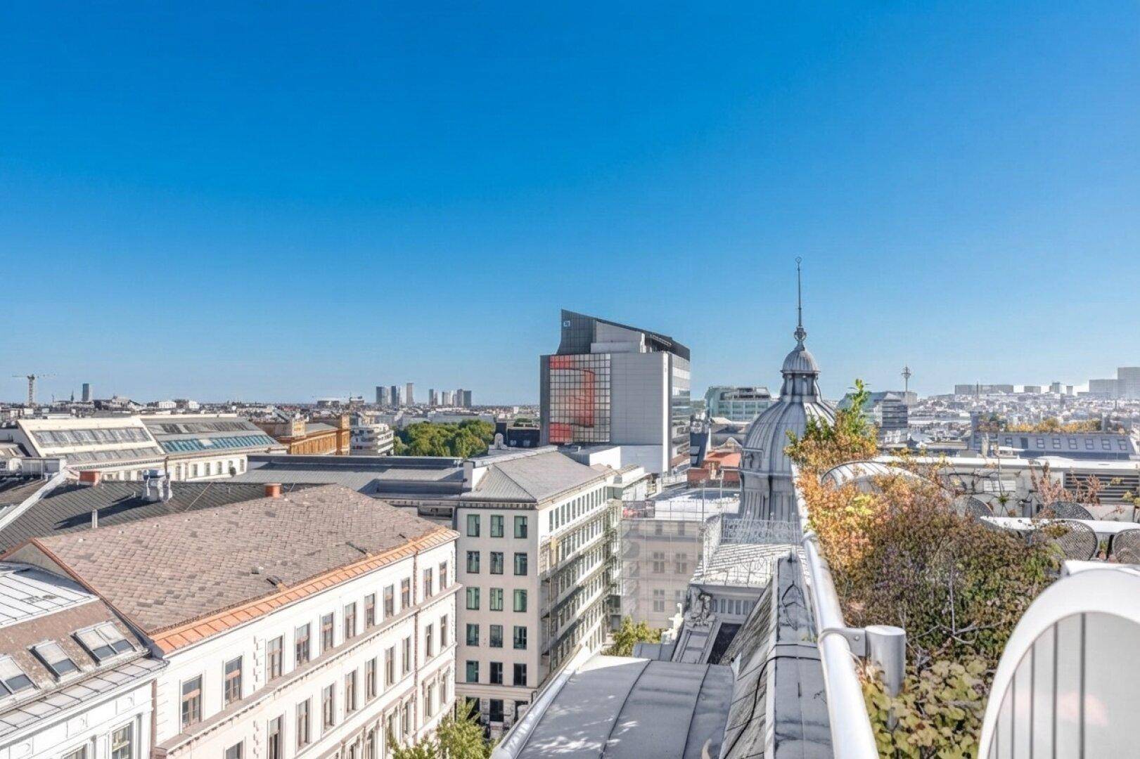 Panoramablick über die Dächer der Stadt mit modernen und historischen Gebäuden.