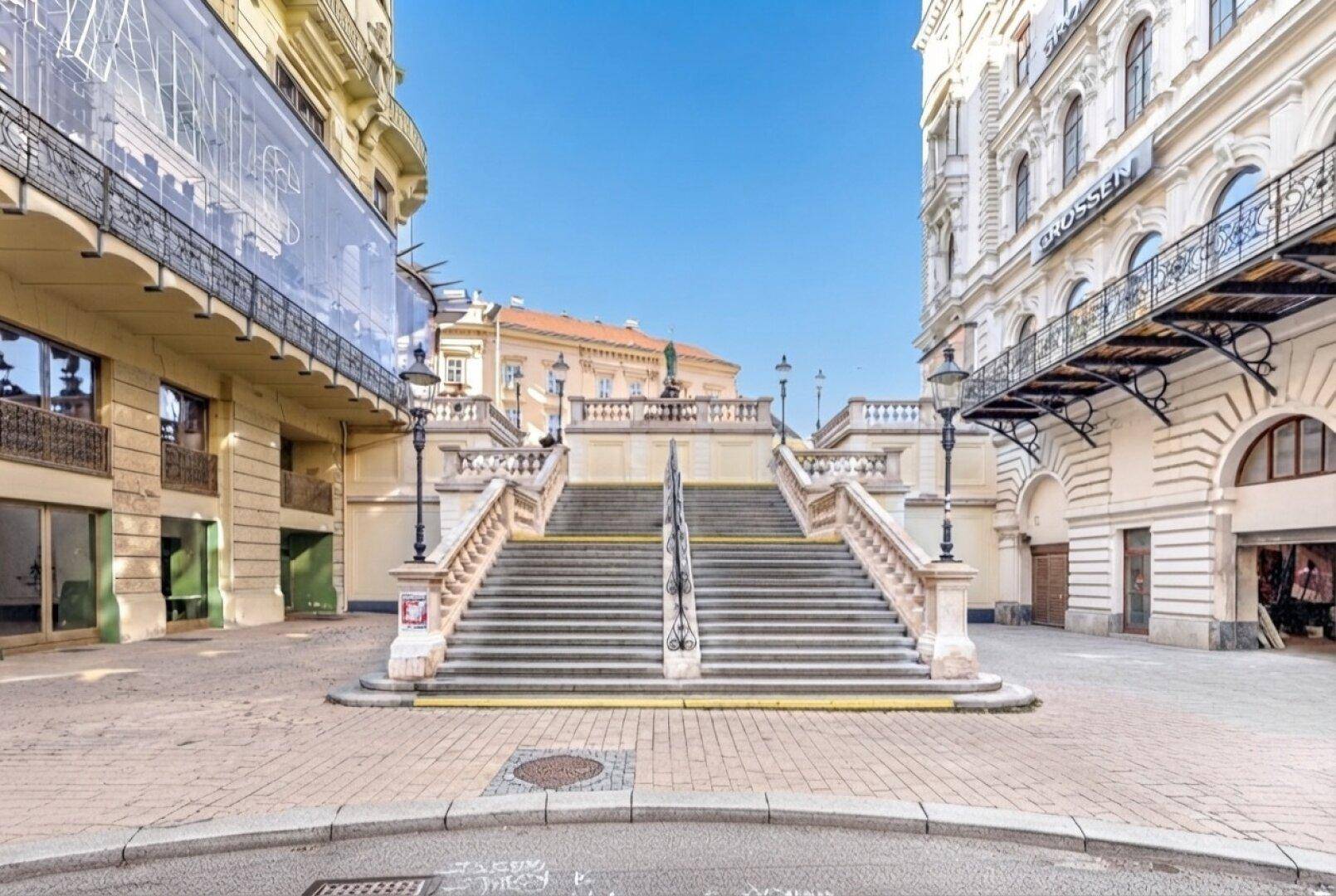 Historische Steintreppe in einer städtischen Umgebung mit beeindruckender Architektur.