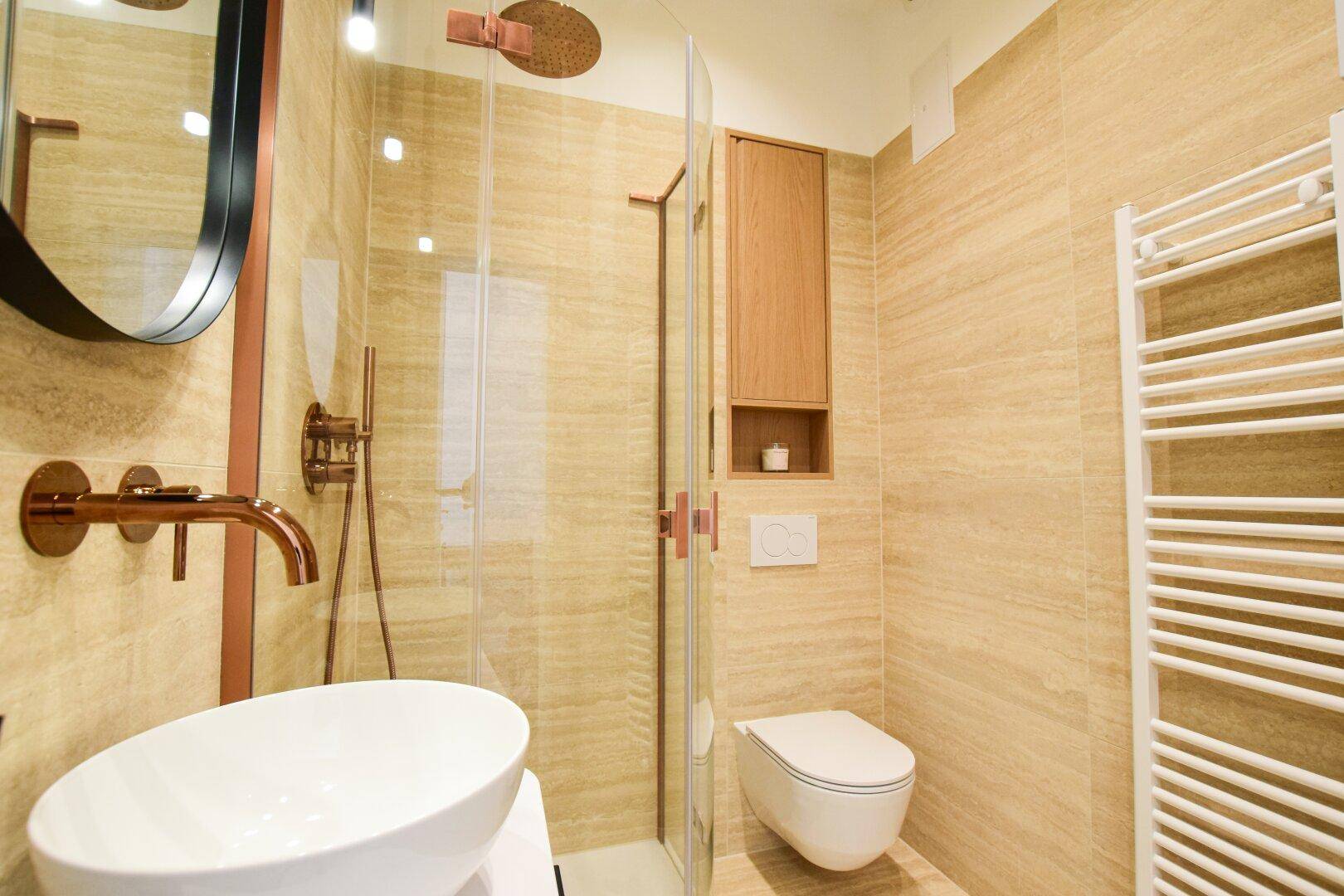 Modernes Badezimmer mit beigefarbenen Fliesen, ebenerdiger Dusche und Wand-WC.
