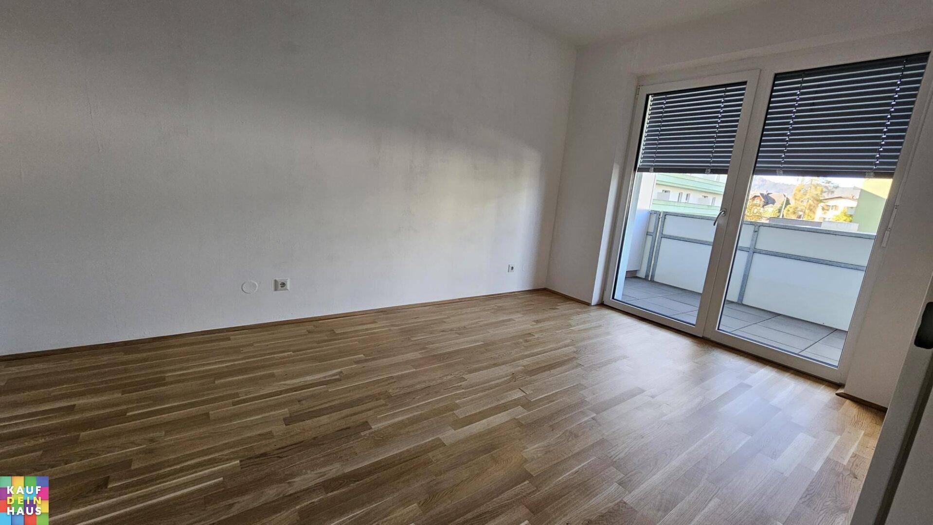 Helles Schlafzimmer mit Holzboden und direktem Zugang zu einem Balkon.
