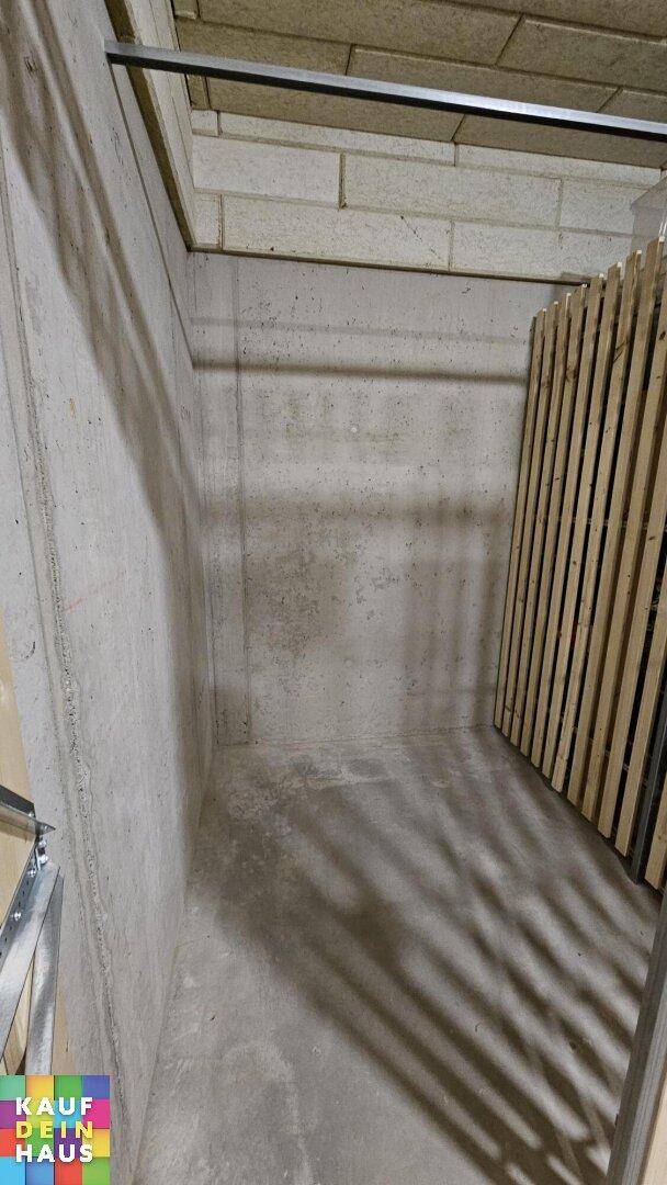 Geräumiges Kellerabteil mit Betonwänden und -boden, ideal für Lagerzwecke.