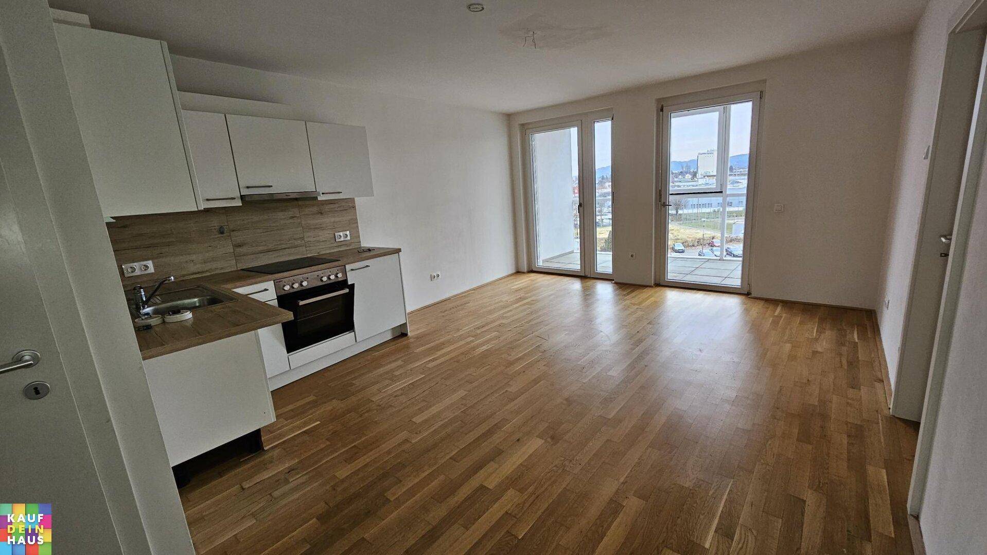 Lichtdurchfluteter Wohnbereich mit integrierter Küche und großzügigem Zugang zum Außenbereich.