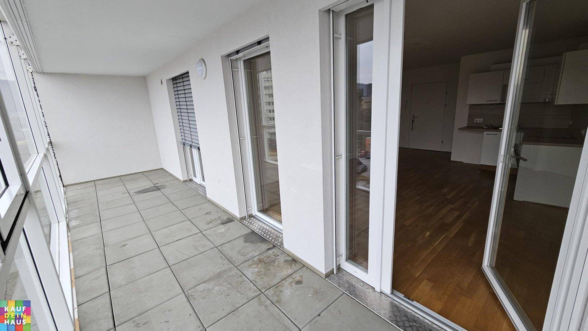 Geräumige verglaste Loggia mit Fliesenboden, ideal als erweiterter Wohnraum.