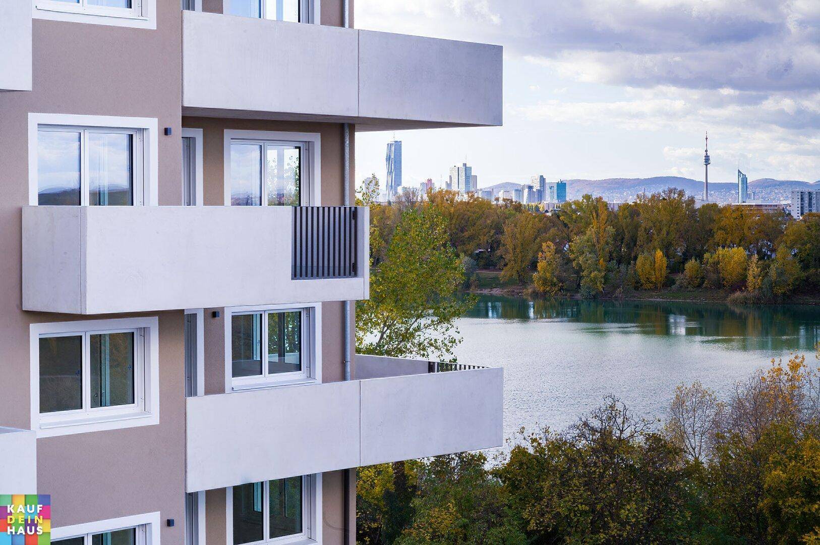 Detailansicht der modernen Gebäudefassade mit Balkonen und weitem Blick auf den See und die Stadt.