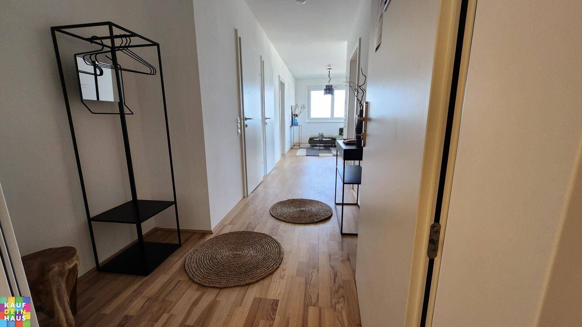 Heller Flur mit Holzfußboden und modernen Garderobenmöbeln.