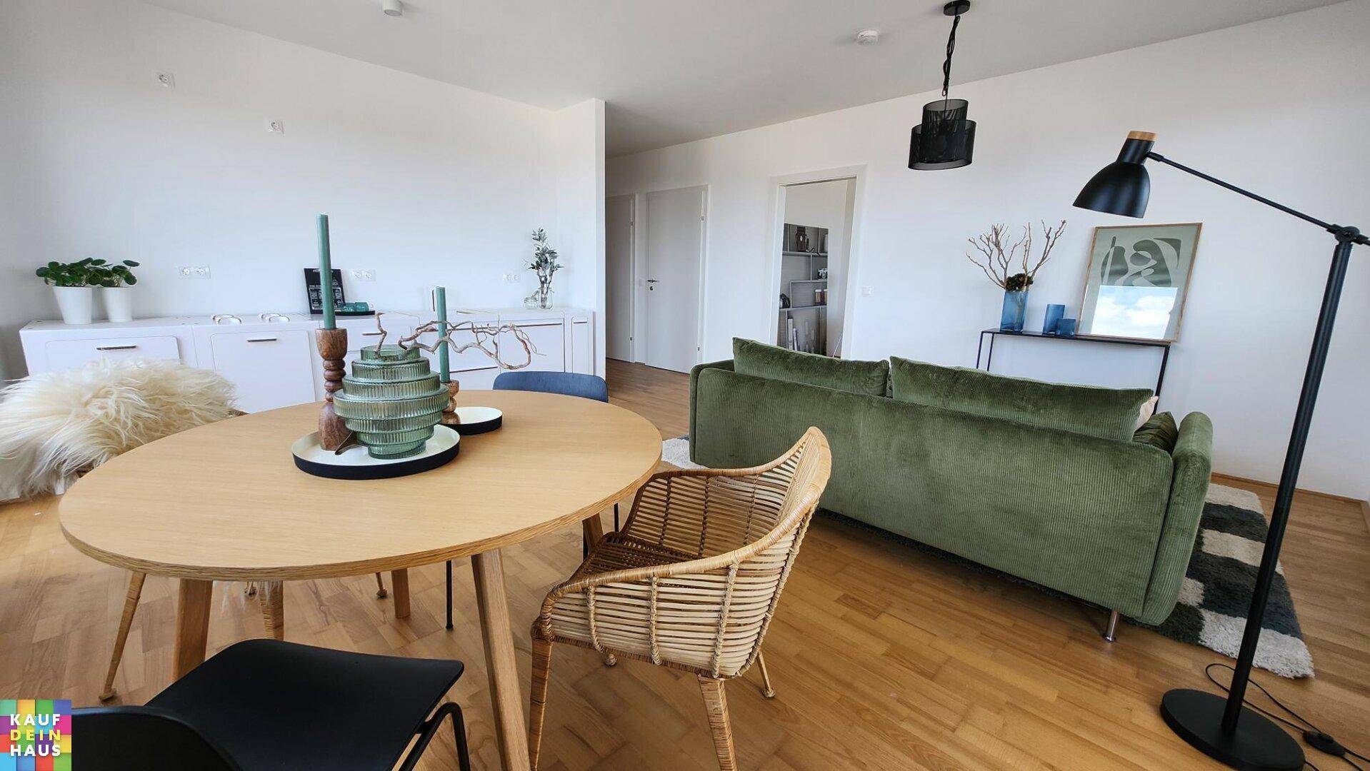 Wohn- und Essbereich mit Holzboden, modernem Sofa und Esstisch.