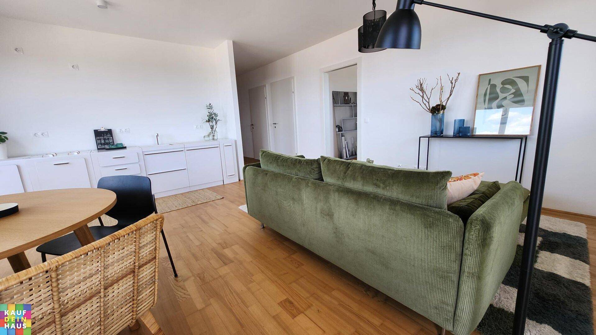 Heller offener Wohn- und Essbereich mit Holzfußboden und moderner Einrichtung.