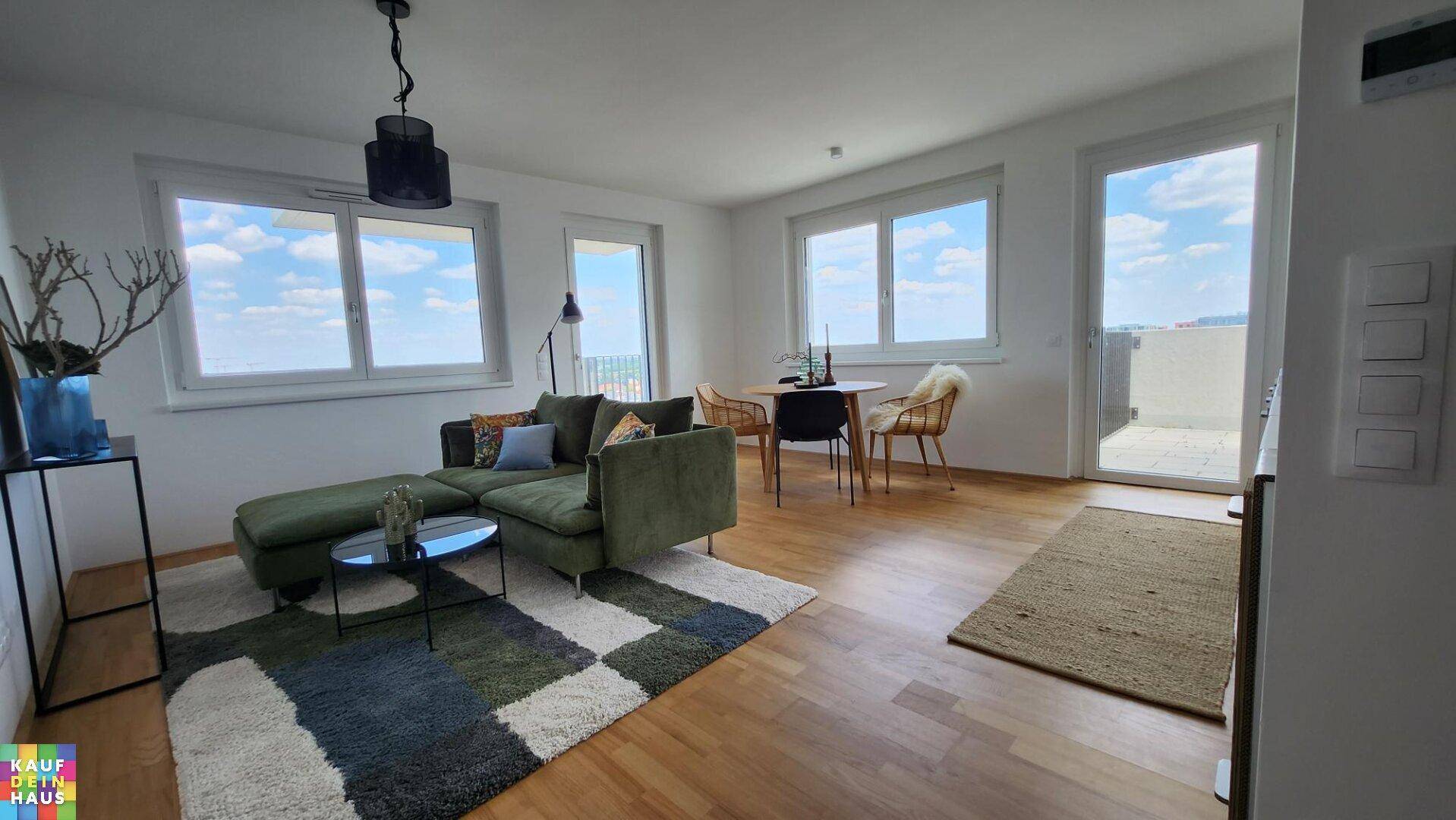 Lichtdurchfluteter Wohnbereich mit Zugang zum Balkon und Blick ins Freie.