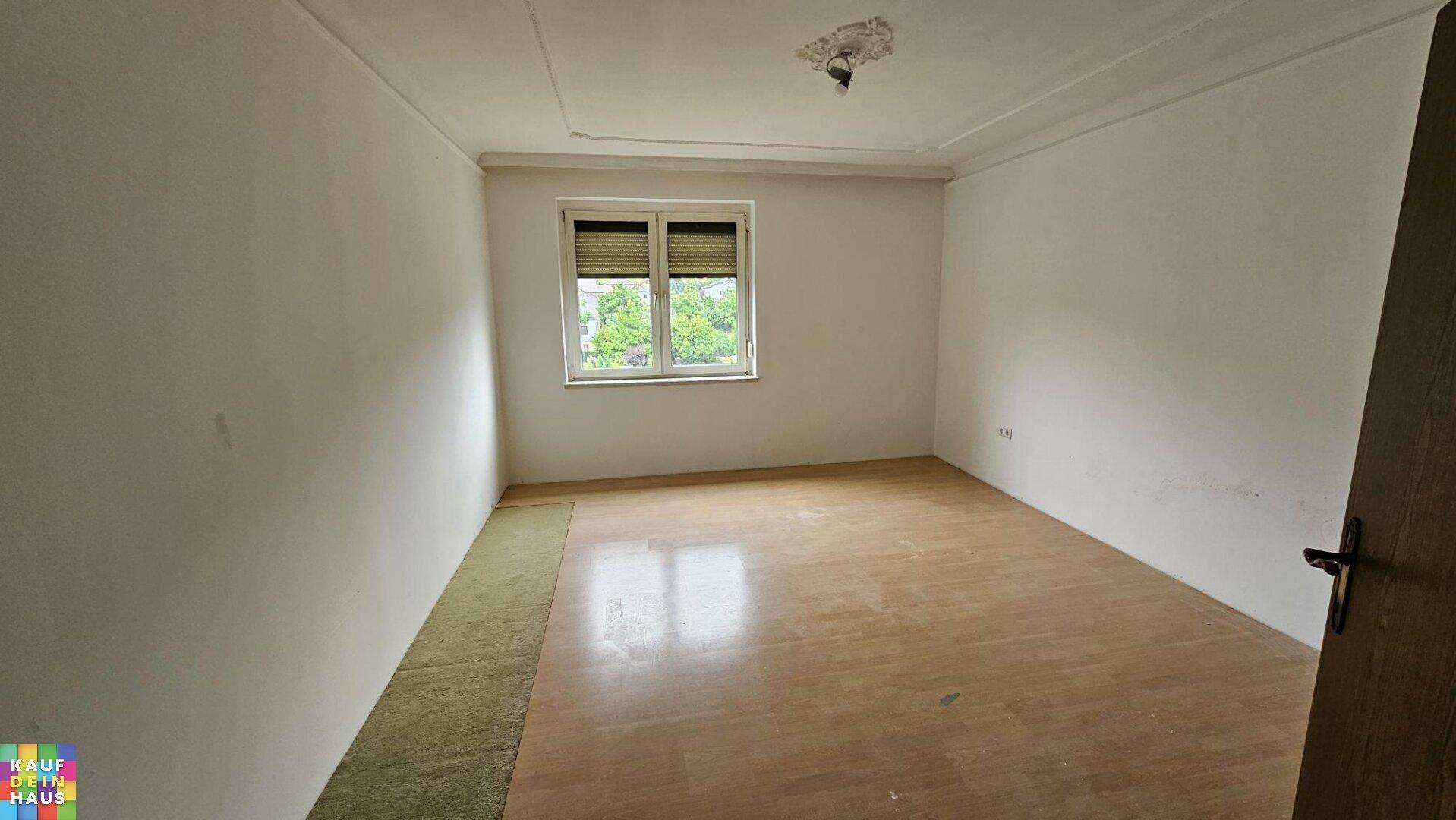 Heller, leerer Raum mit einfacher Decke und Fenster, bereit zur individuellen Gestaltung.