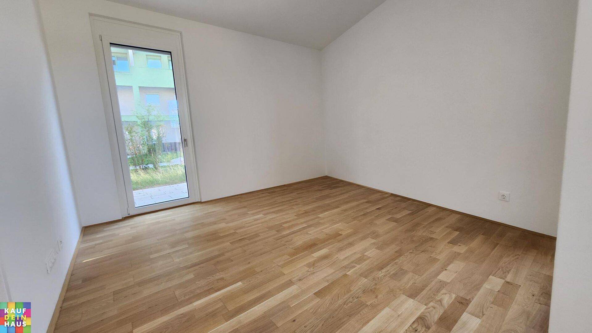 Helles Schlafzimmer mit Holzboden und direktem Zugang zu einem kleinen Außenbereich.