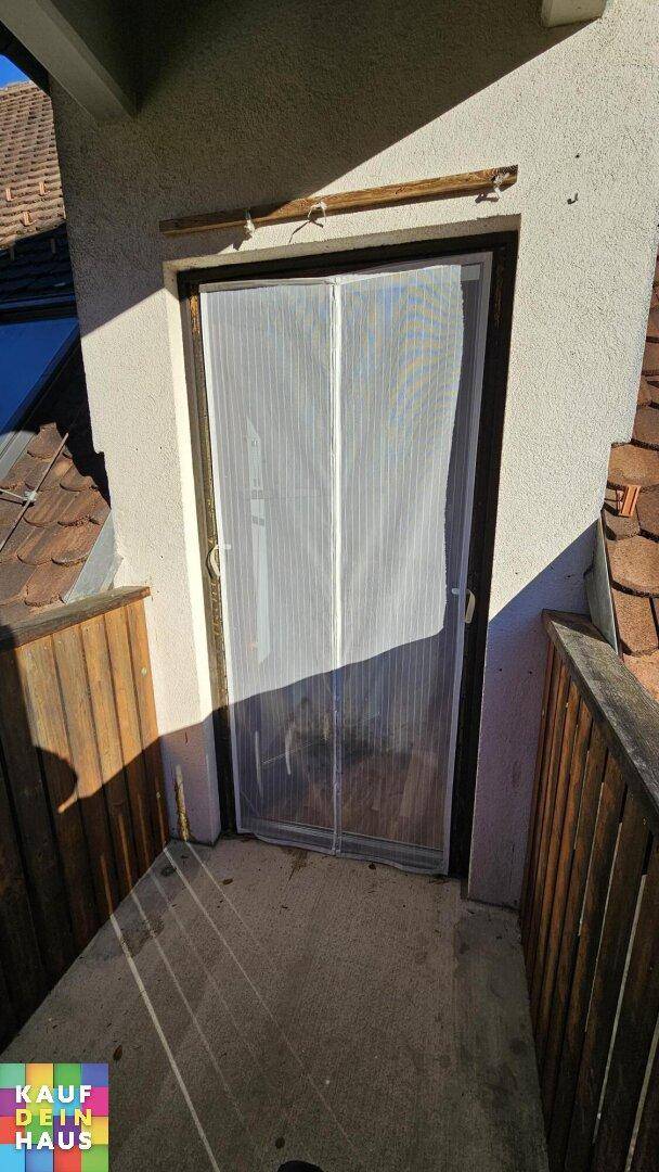 Balkonzugang mit Insektenschutzgitter und Holzbalkonbrüstung.