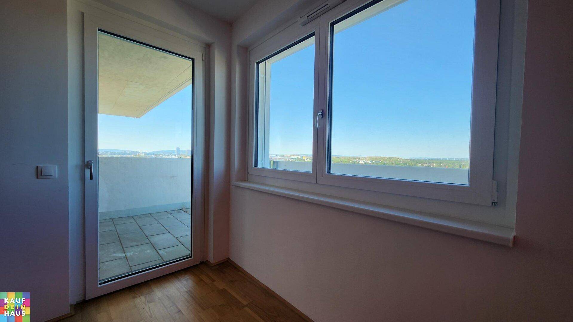 Fenster und Balkontür bieten einen weiten Blick und lassen viel Tageslicht in den Raum.