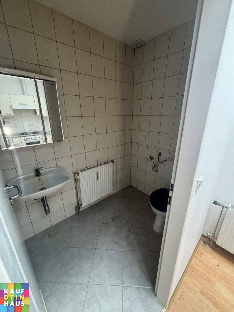 Funktionales Gäste-WC mit Waschbecken, Spiegelschrank und hellen Fliesen.