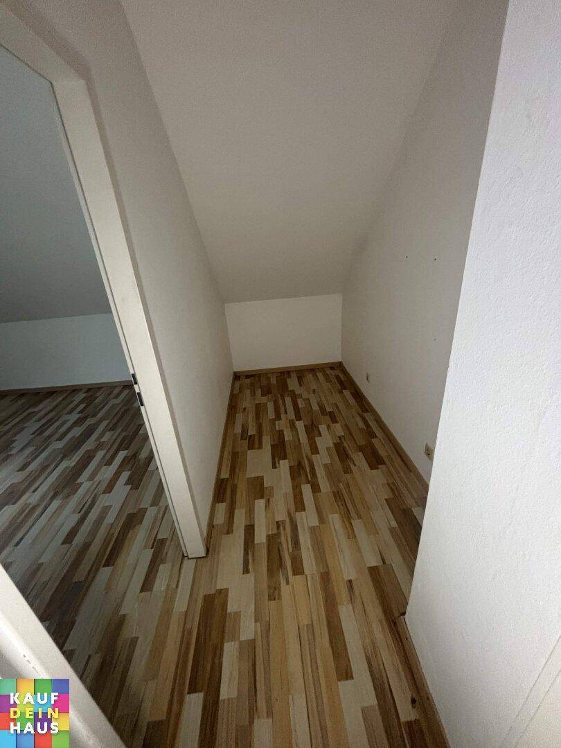 Leerer Raum mit Dachschräge und Laminatboden, vielseitig als Abstellraum nutzbar.