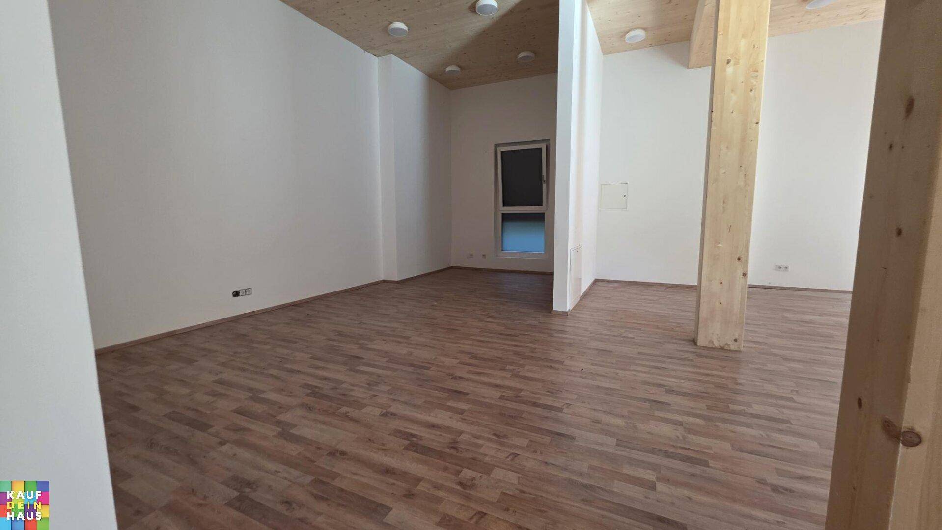 Geräumiger, leerer Raum mit Holzboden und Holzträgern, bereit für individuelle Gestaltung.