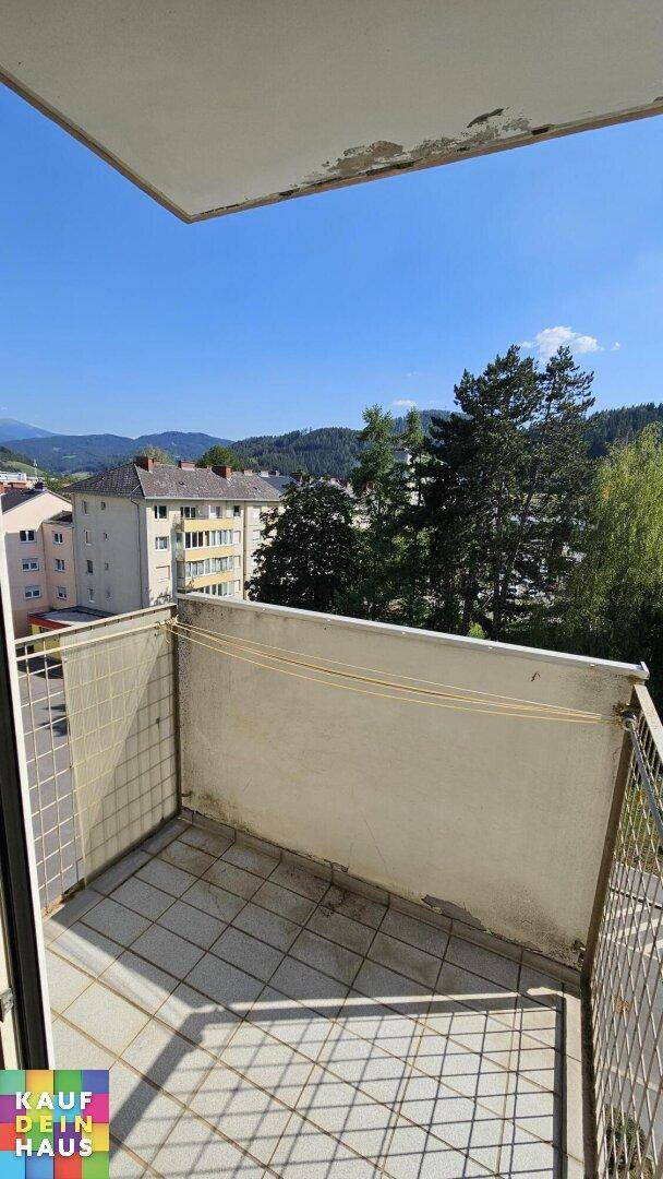 Kleiner Balkon mit Fliesenboden und Bergblick, ideal für entspannte Stunden im Freien.