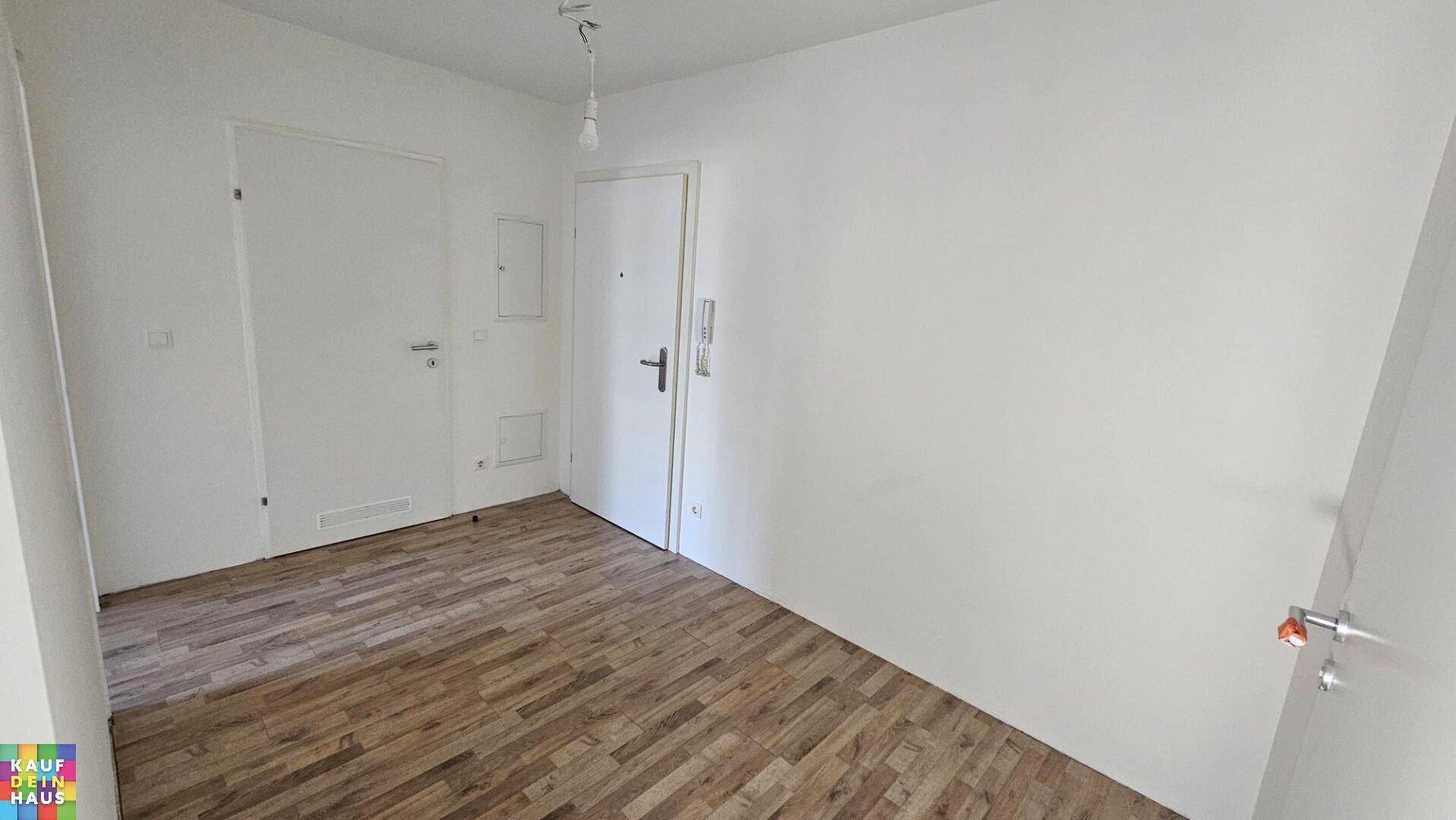 Eingangsbereich oder Flur mit Laminatboden und weiß gestrichenen Wänden.