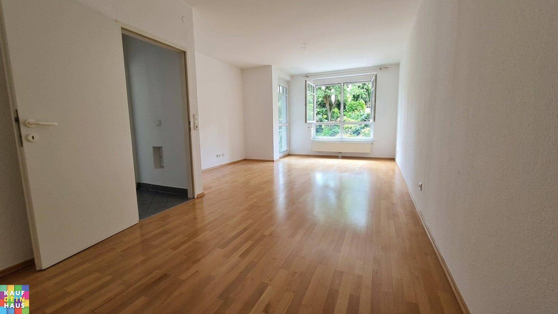Heller Wohnbereich mit Laminatboden und Zugang zu einem weiteren Raum, ideal für offenes Wohnen.