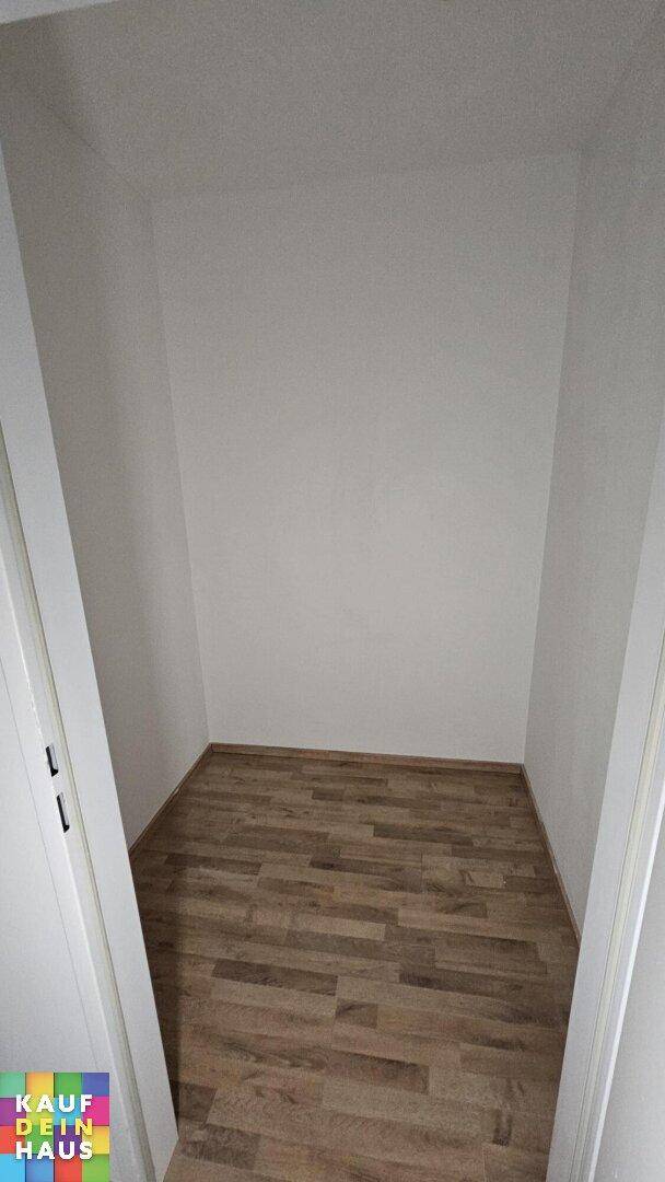 Praktischer Abstellraum mit Holzboden, ideal für zusätzlichen Stauraum oder als begehbarer Kleiderschrank.