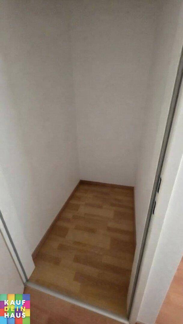 Praktischer Abstellraum mit Laminatboden und weißen Wänden für zusätzlichen Stauraum.