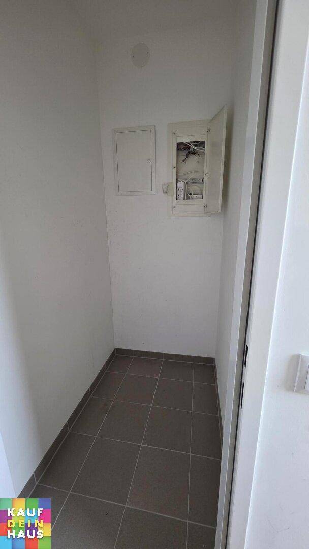 Kleiner Abstellraum mit Fliesenboden und Elektroverteilerkasten, ideal für zusätzlichen Stauraum.